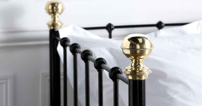 black iron day bed with brass detailing 