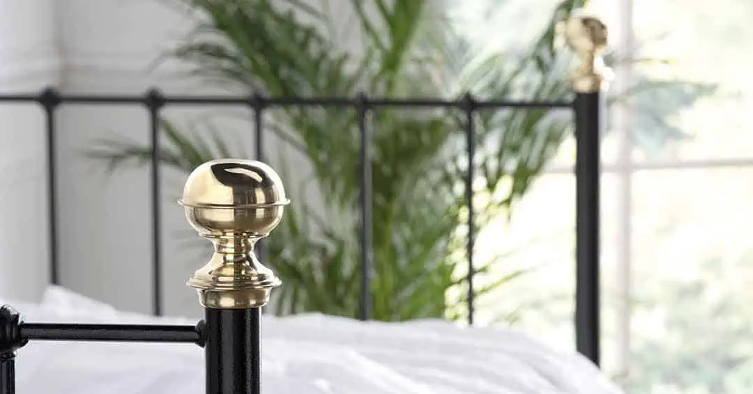 Victorian-style Garce day bed in black metal with brass knob and leafy backdrop for a vintage feel