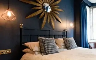 room shot of black iron and brass bed