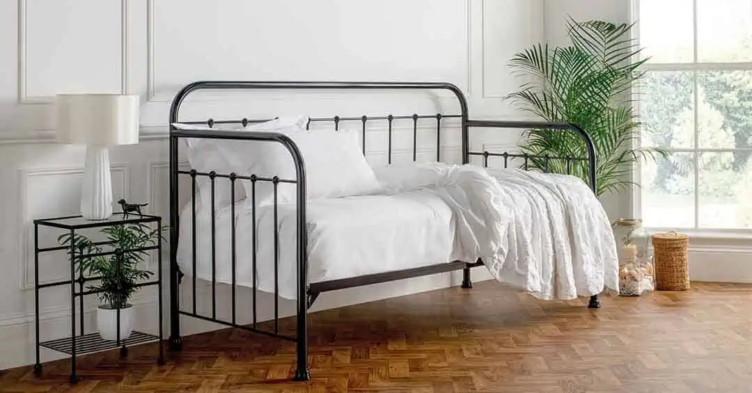 Edward day bed in nickel finish with black details, styled with white bedding in a parquet-floored room