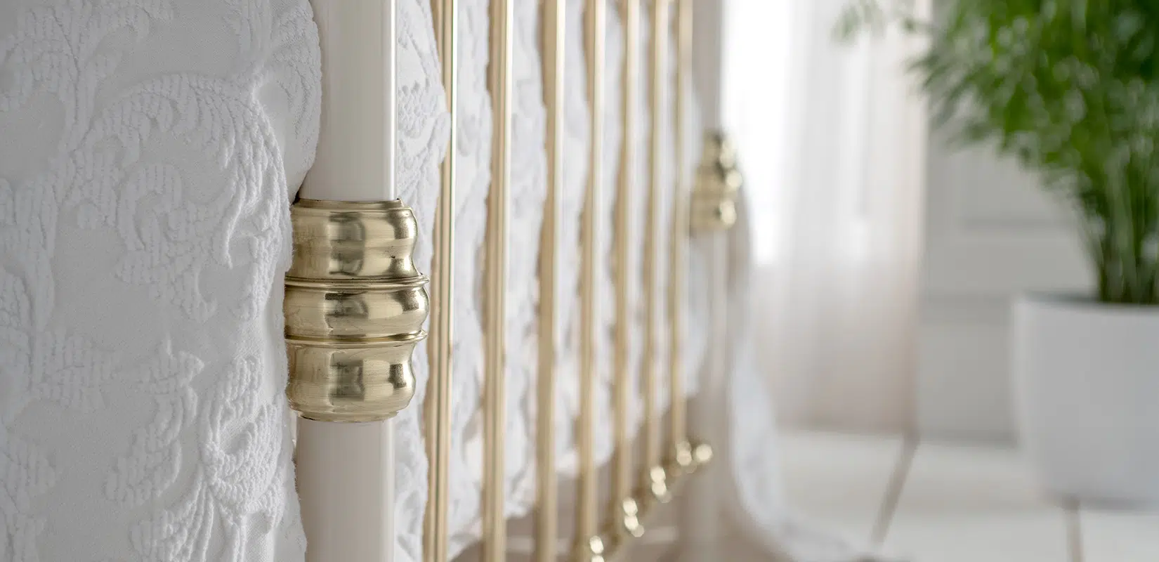 Polished brass footboard of Elizabeth bed frame with tapered vertical rods and traditional finish
