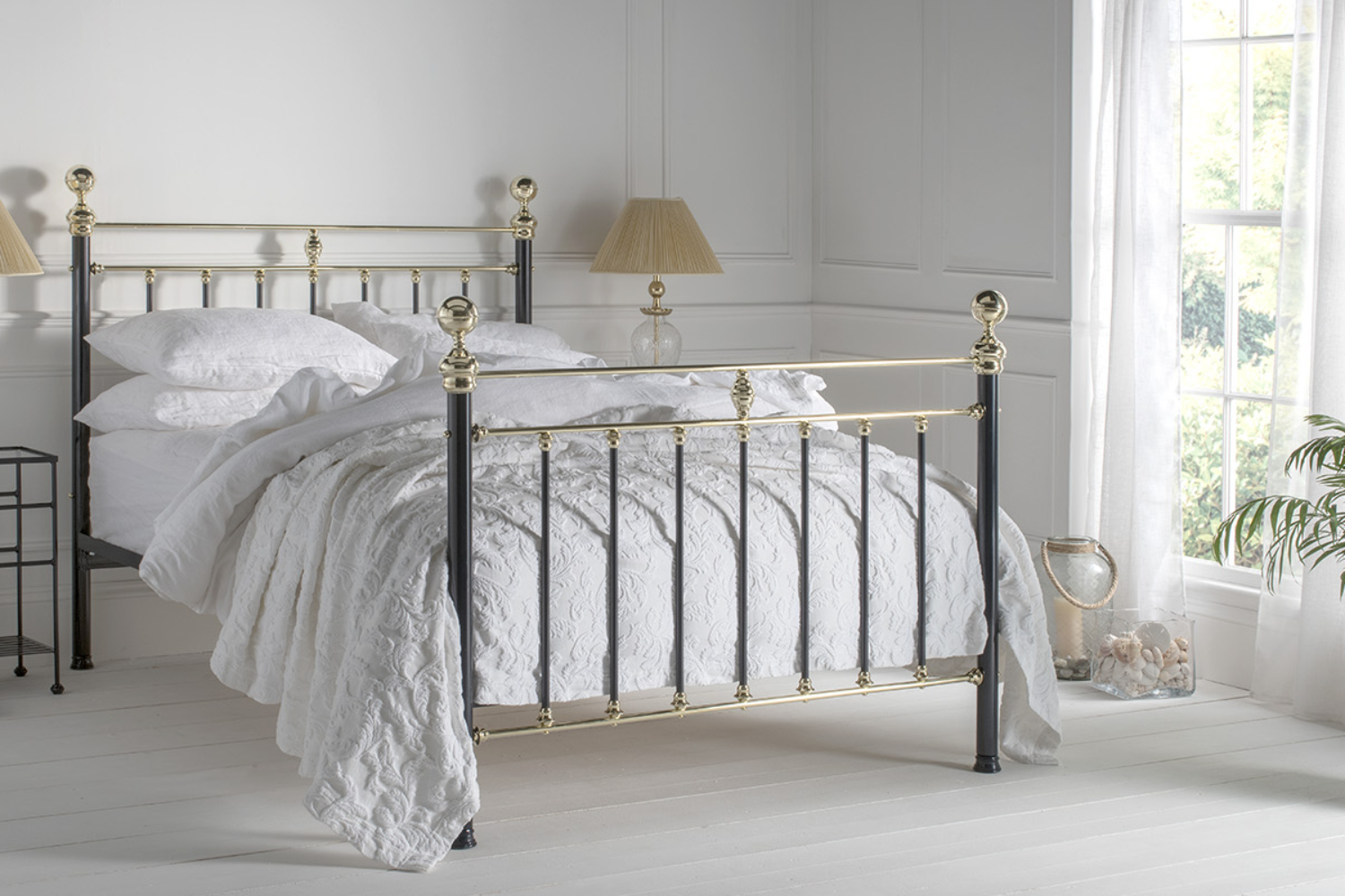Frederick bed with black iron posts and polished brass details in a classic white bedroom