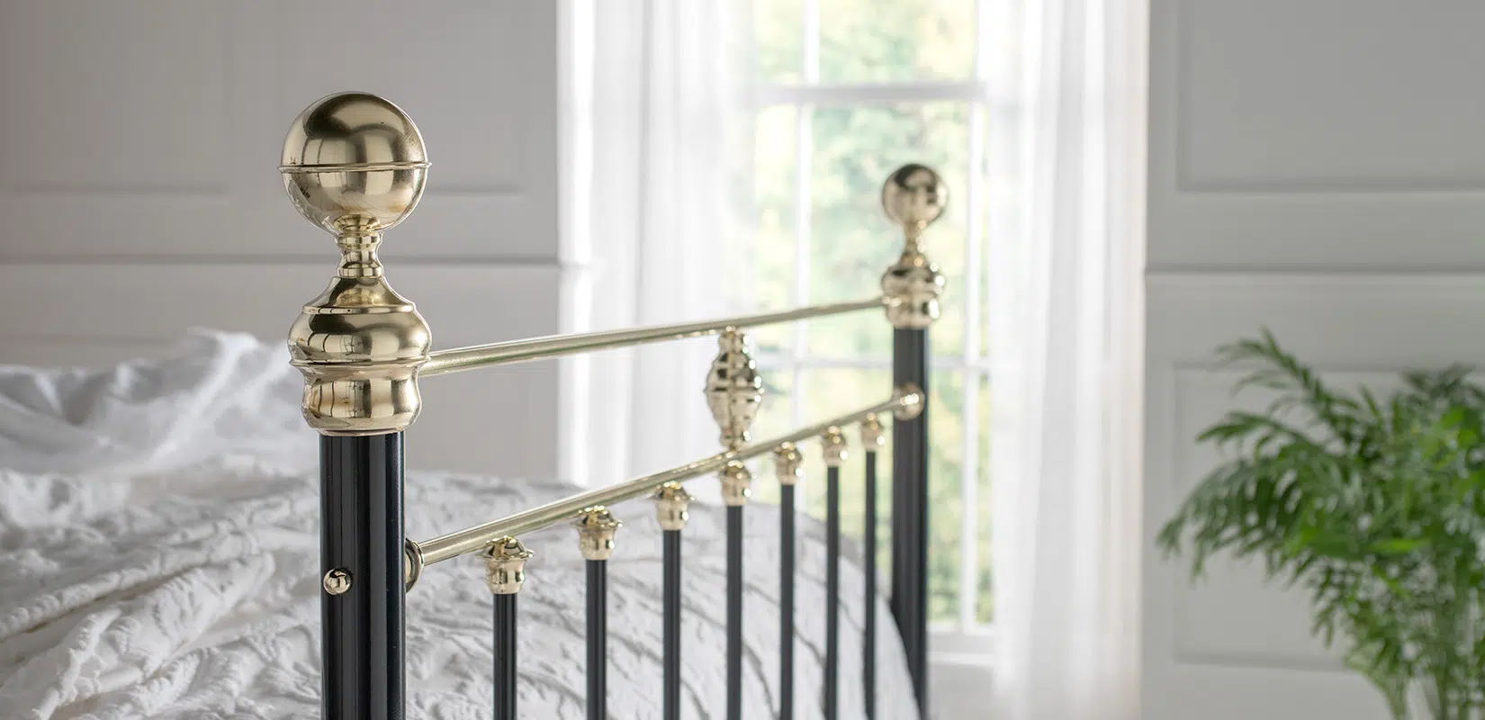 Detailed view of Frederick bed’s polished brass top rail and decorative castings
