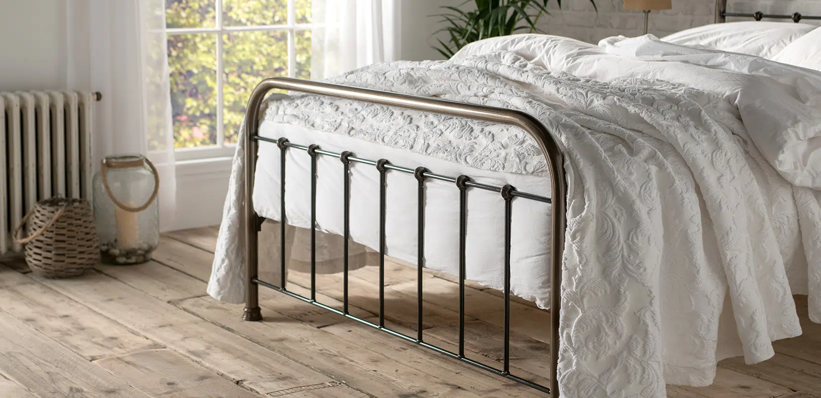 Side view of Edward  bed’s footboard with gentle antique detailing and turned finials