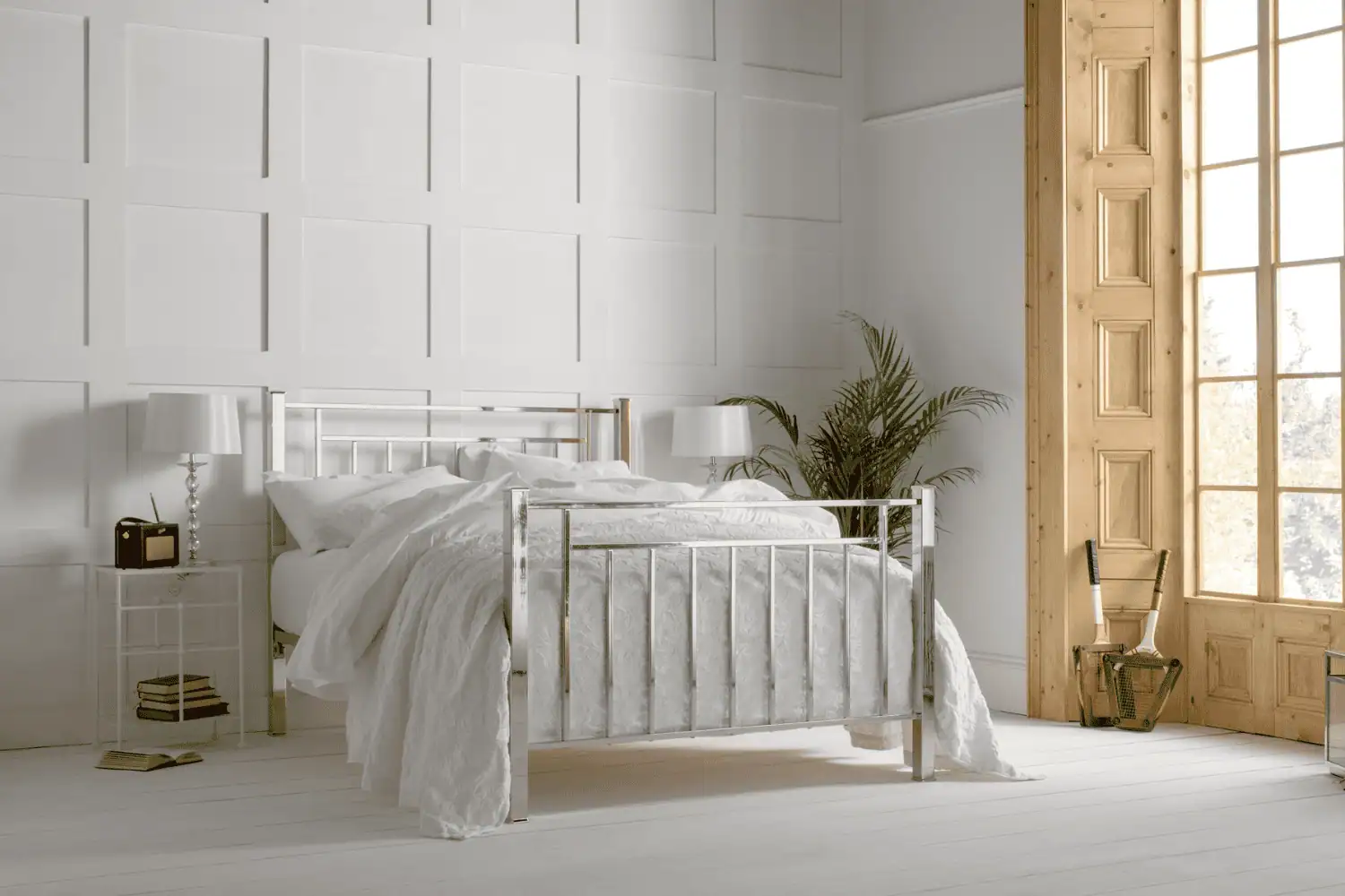 Nickel bed frame with high headboard and footboard, finished in bright silver tones in a neutral bedroom