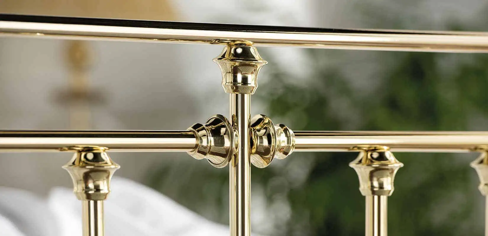 Zoomed view of Willow bed’s upper brass rail with decorative knuckle joint