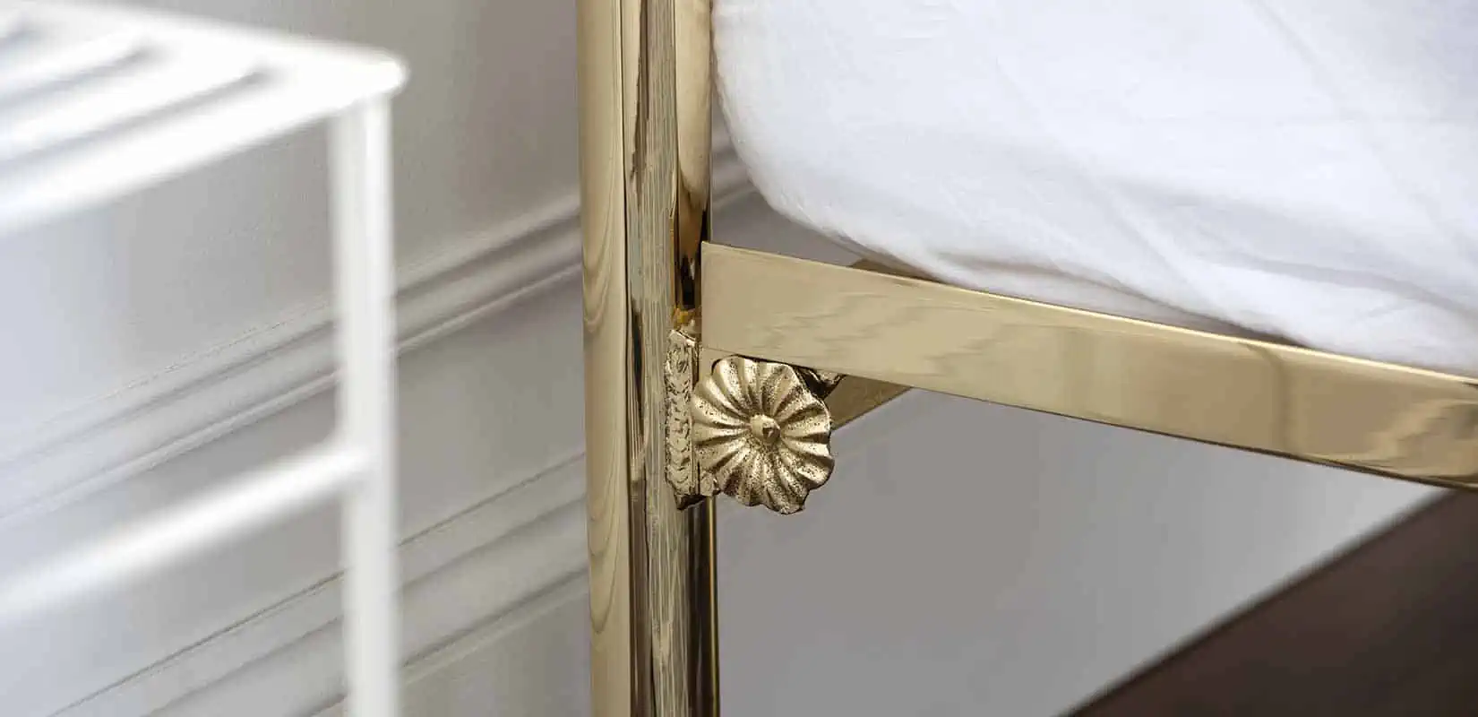 Close-up of bed rail connection point with intricate brass rosette detailing