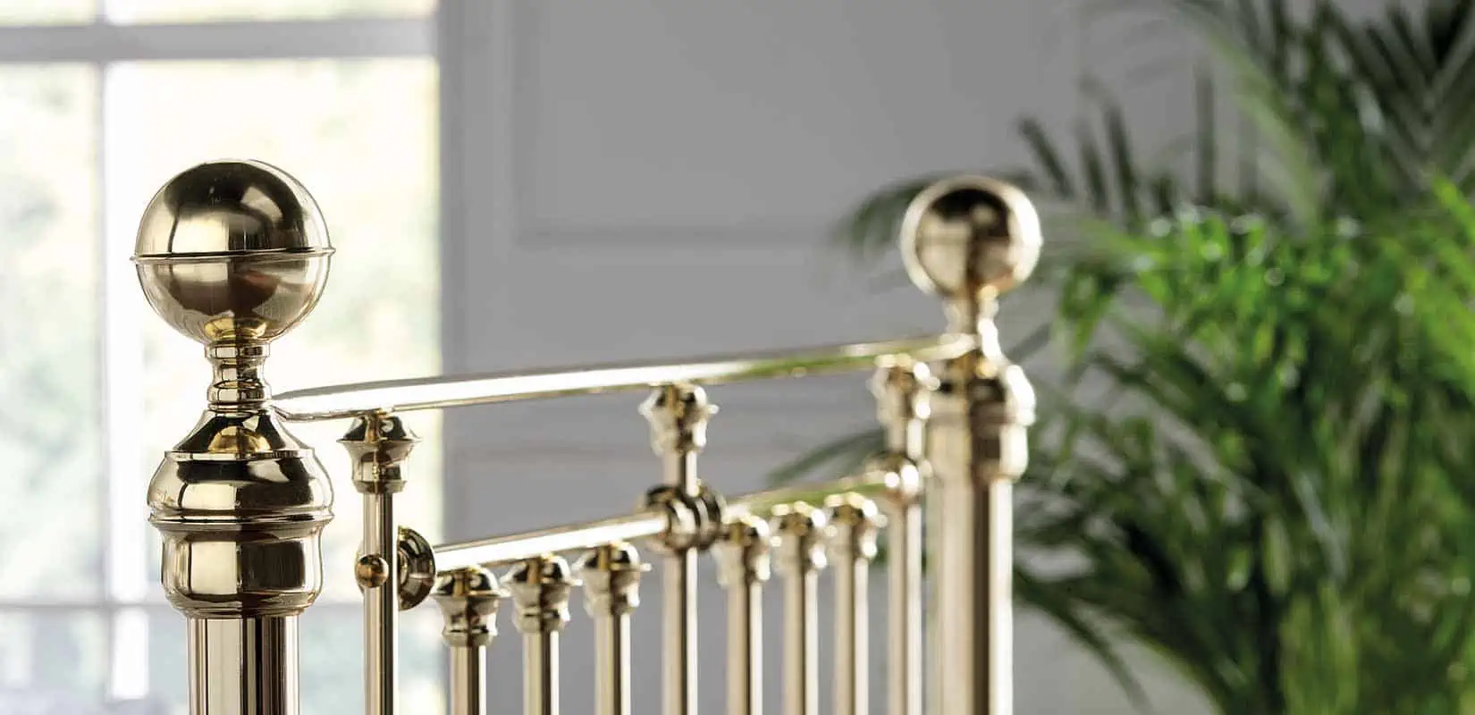 Detailed corner of Willow brass bed with round brass finial and curved top rail