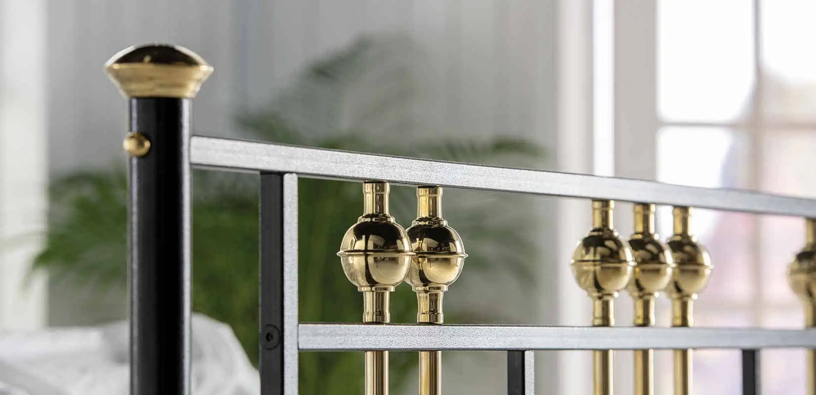 Detailed view of Dolly bed’s twin brass spheres and iron rail construction