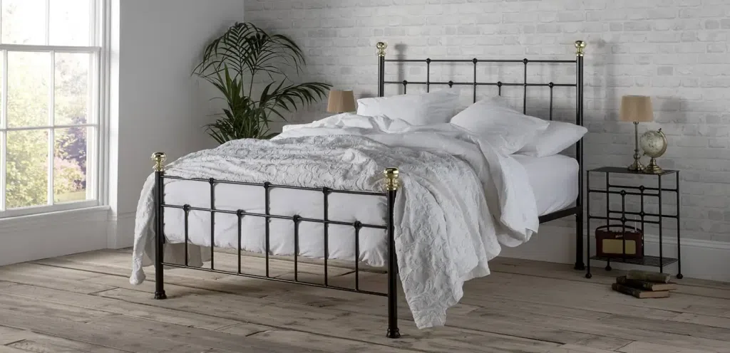 Wrought iron bed with brass finials
