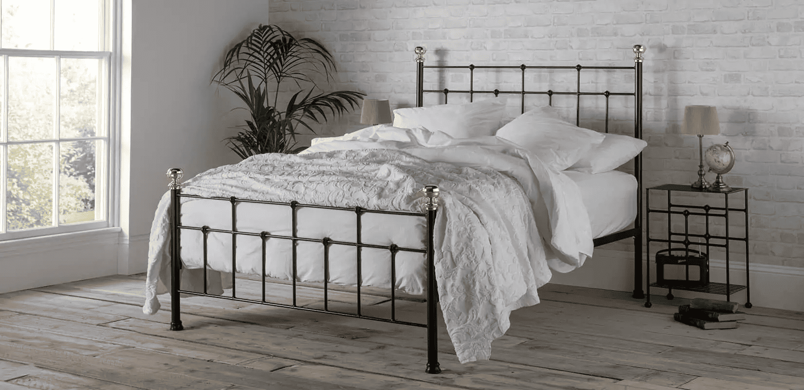 Wrought iron bed with brass finials