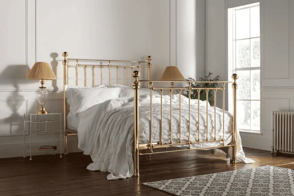 king size victorian inspired brass bed in a plated brass finish - situated in a georgian style bedroom with white walls and dark oak flooring