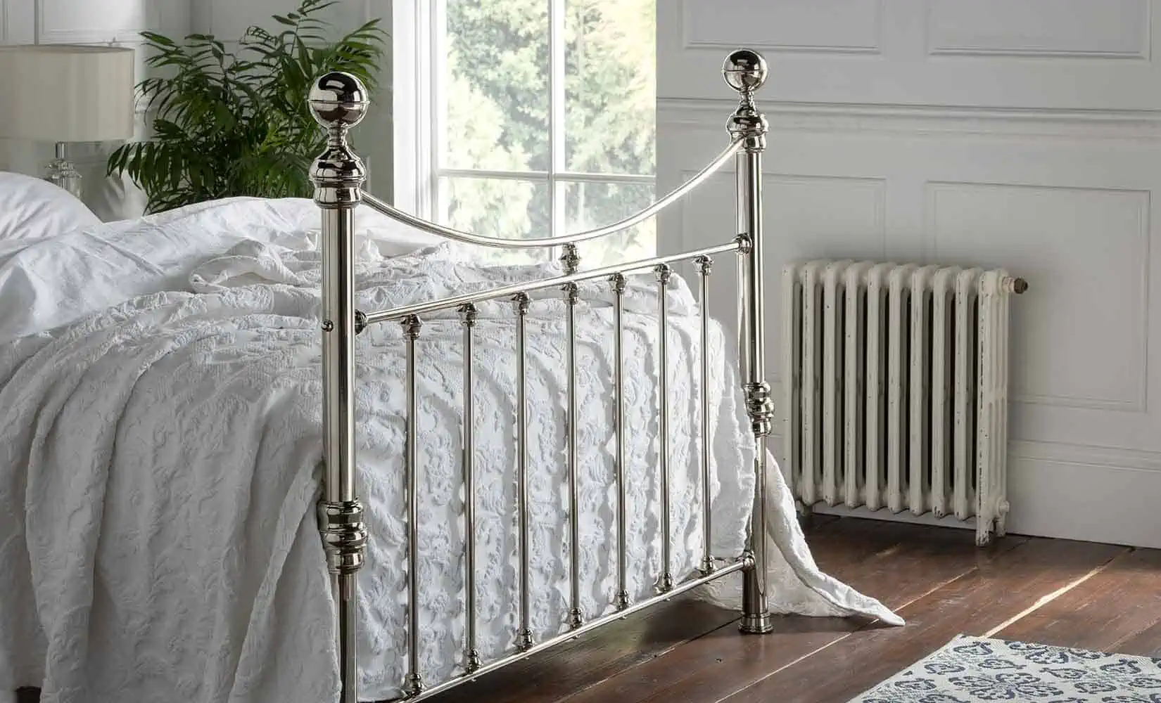 Side view of Alice bed showing full tailboard with decorative nickel finish and classic vertical bars