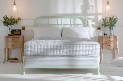 Handmade bed with upholstered headboard, natural fibre pocket spring mattress and bed base in a light-filled bedroom