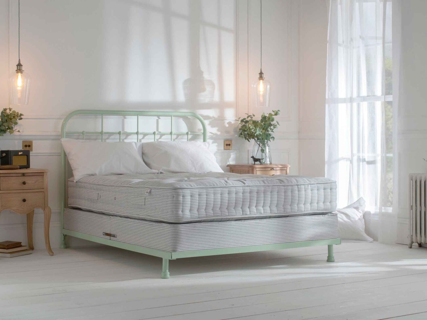 Handmade Iron Bed with Natural Fibre Pocket Spring Mattress and Bed Base Light green in bright airy bedroom with large windows