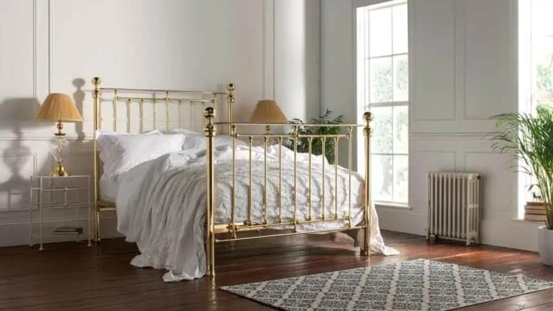 a victorian style iron bedframe finished in an all brass finish