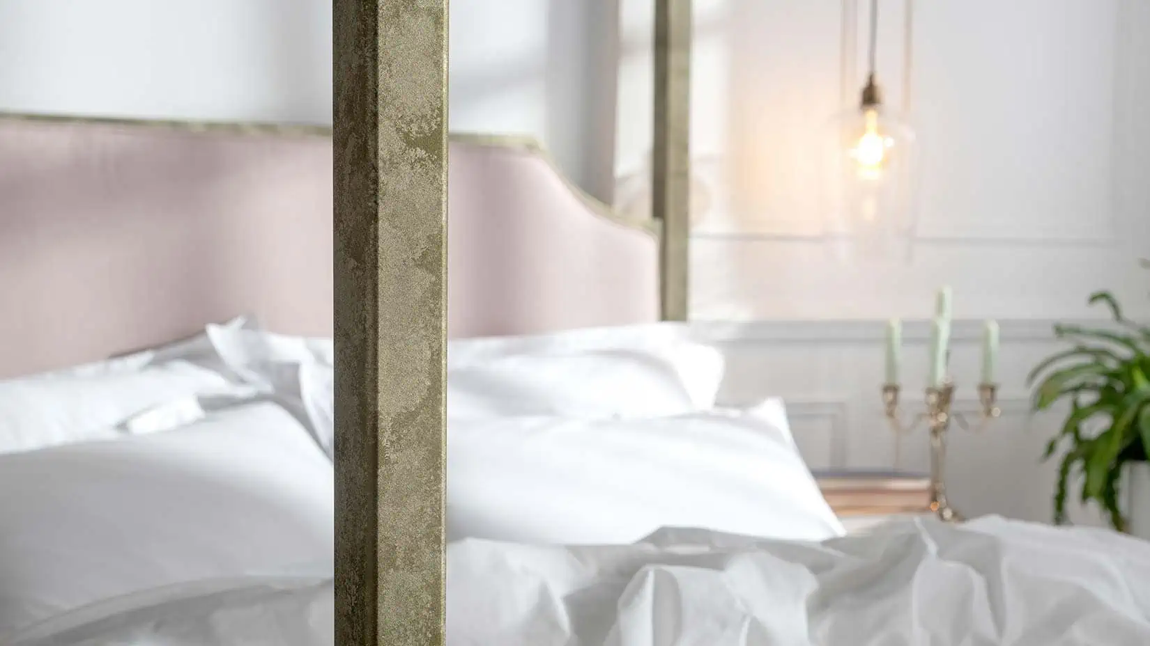 Close-up side view of Aurora four-poster bed showcasing pink velvet headboard and luxurious white bedding