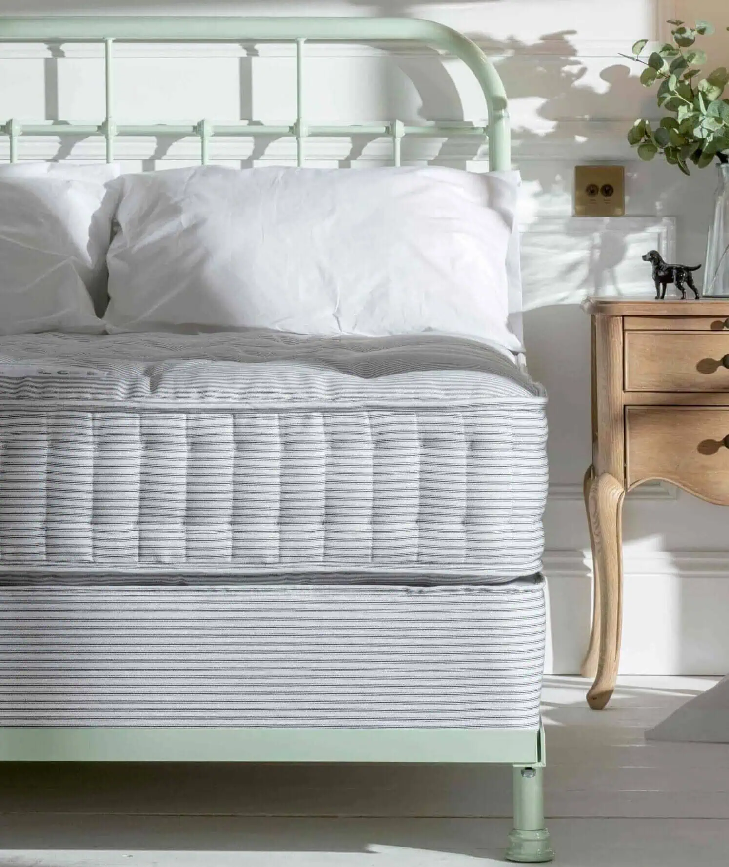 Bed base sprung top in butcher's stripe on mint green iron bed frame
