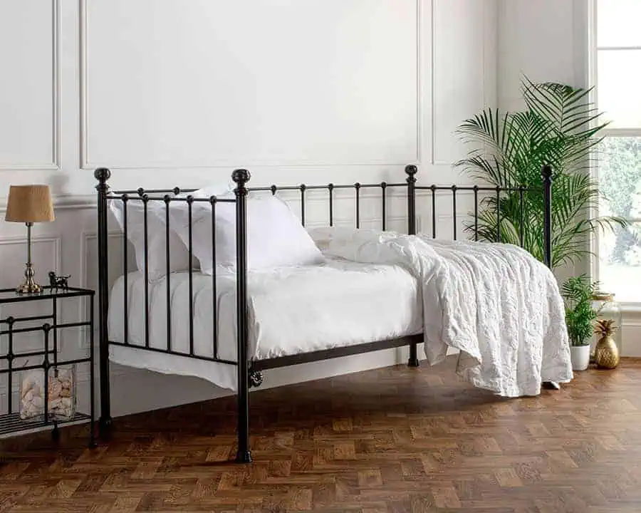 iron day bed dressed in white bedding is the perfect solutiuon for occasional guest rooms and hosting guests over Christmas