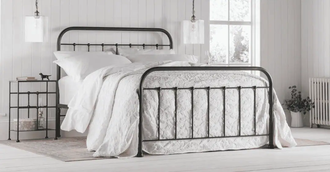 black metal bedframe in a white bedroom