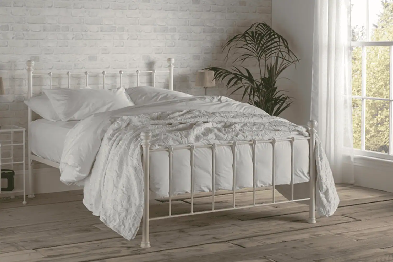 The Grace iron bed frame with soft curves and supportive slats, styled in a bright bedroom with neutral tones
