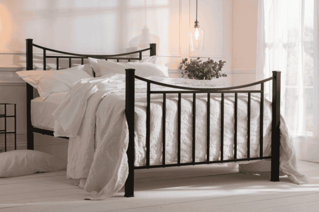 black iron bed king size with white bedding and soft warm white lighting