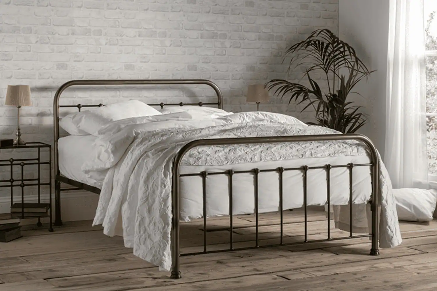 The Edward traditional iron bed with curved headboard and clean cast feet, shown in a heritage-inspired bedroom