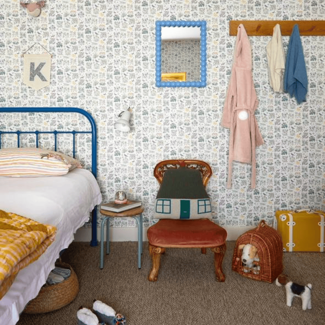 A children’s bedroom featuring a metal bed frame, toys, sports equipment, and playful wall decor.