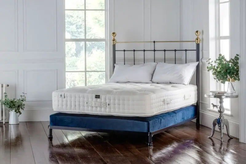 iron bedframe with a wool mattress - the image shows a british wool mattress sitting on a iron bedframe - the mattress sits on a sprung divan base to offer extra comfort and support