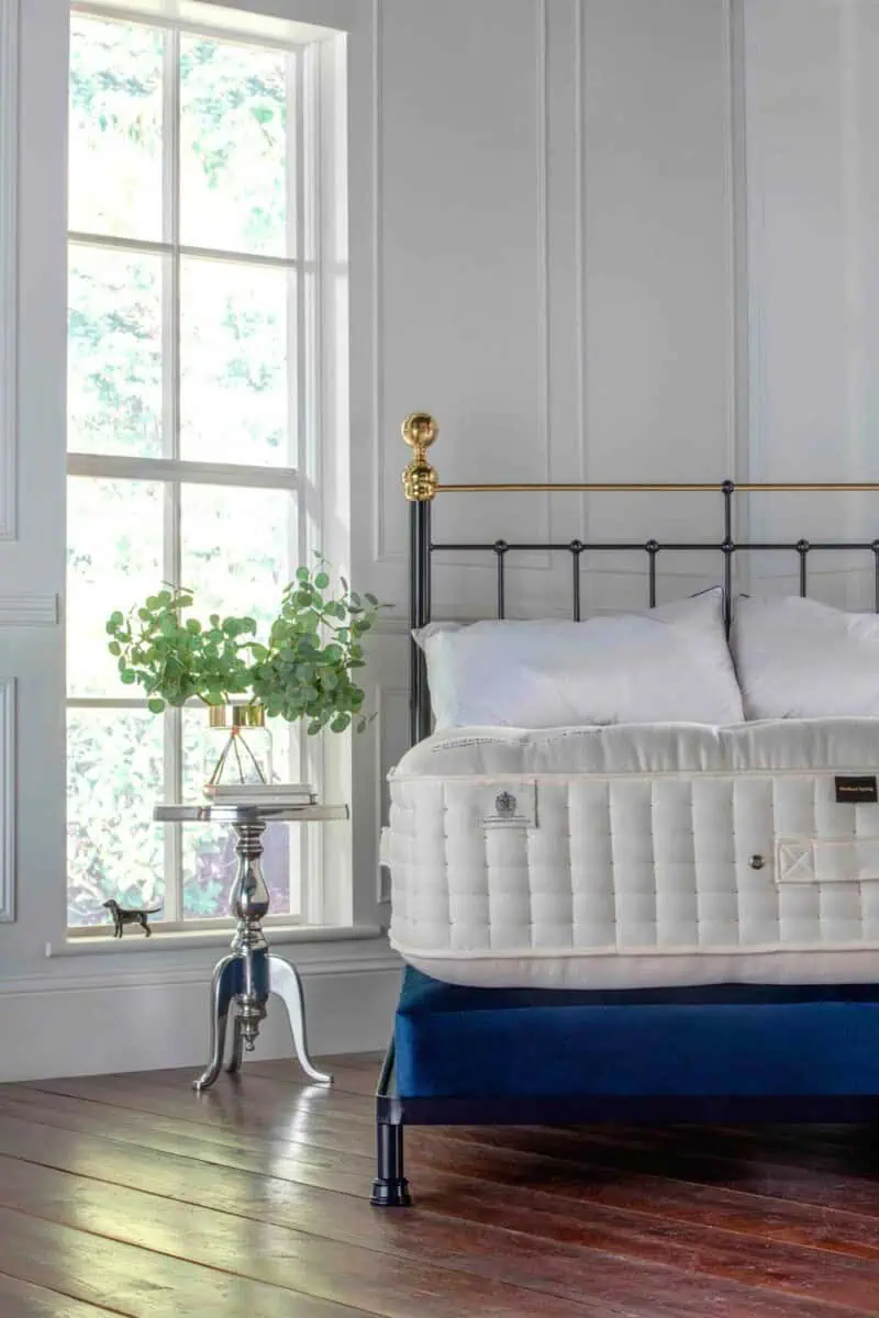 iron bed finished in black finished with brass detailing - the bed has no-footend and its dressed with a wool mattress and sprung divan base