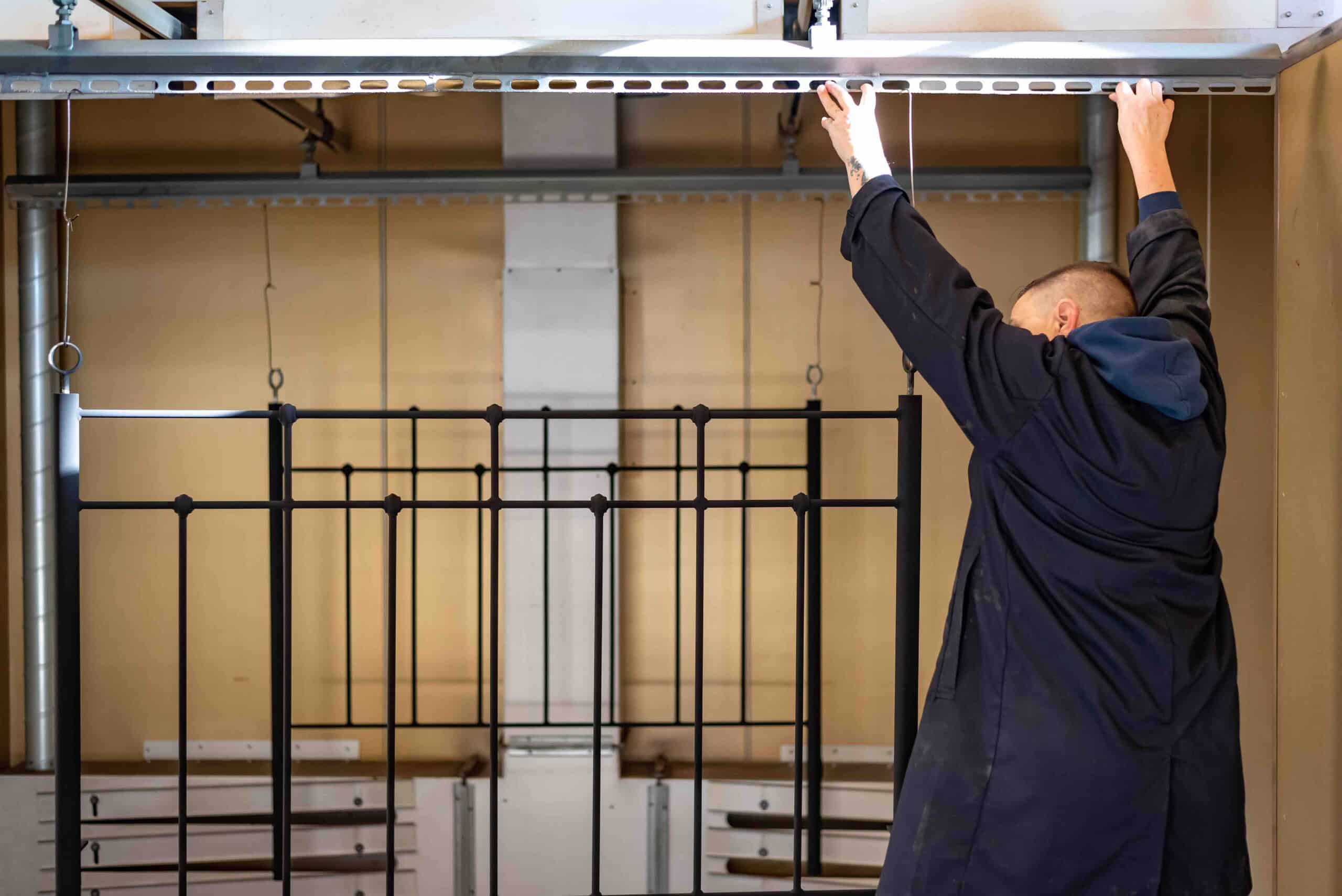 Hand-finishing a British-made wrought iron bed