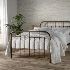The Henry iron bed frame with high headboard and bold black finish, featured in Period Living magazine