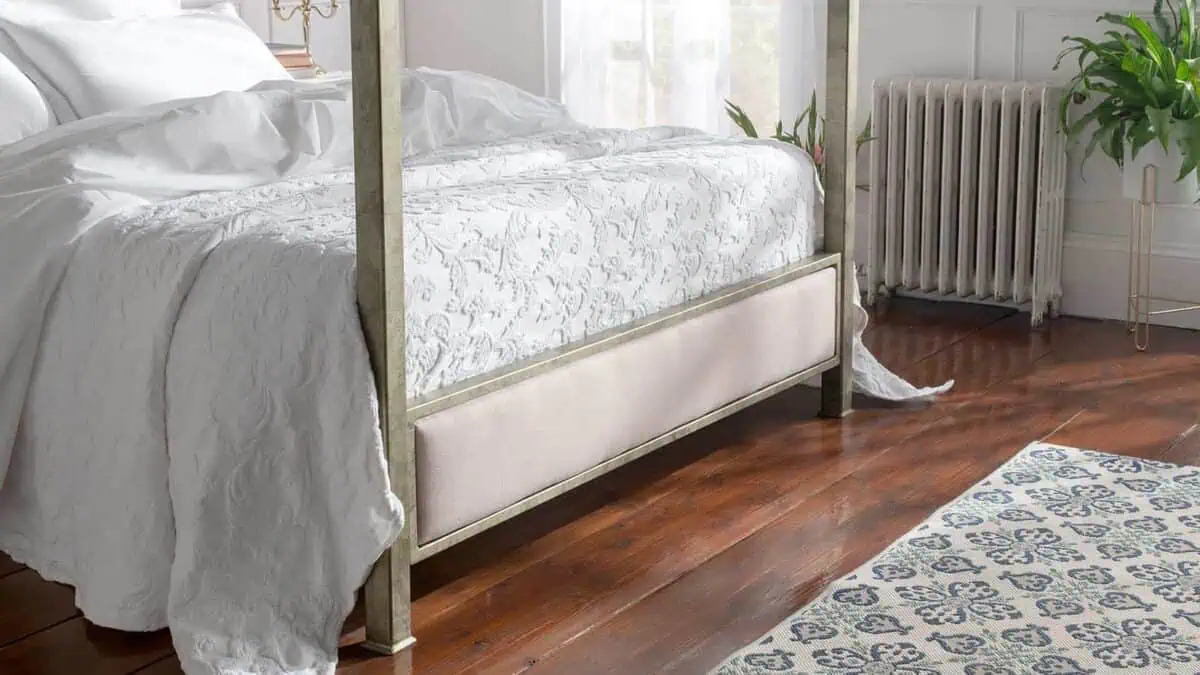 Elegant wrought iron and brass bed in a stylish bedroom setting.