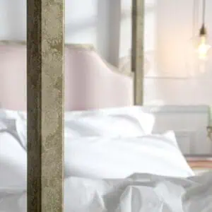 Elegant wrought iron and brass bed with white bedding in stylish bedroom.