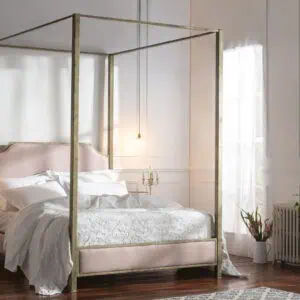 Luxurious wrought iron and brass bed in a bright bedroom setting.